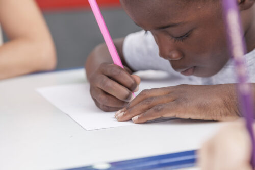 african american child drawing at desk