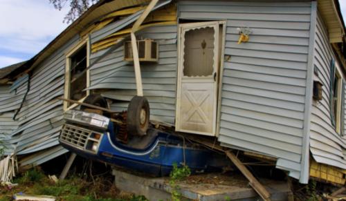 The wreckage of a home sitting on top of an upside down pick up truck. (Image credit: Unsplash/John Middelkoop)