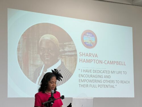 Sharva Hampton-Campbell's photo and name are up on a screen behind the event speaker