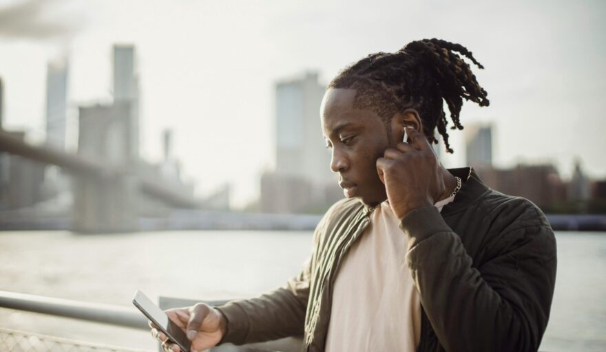 image of black male looking at phone in suburban area