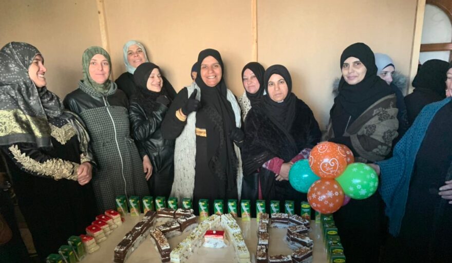 group of women standing together around a table