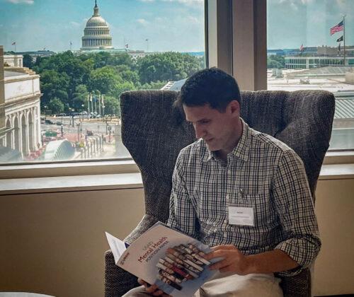 photo of Dean Ben Lough reading report with capital view