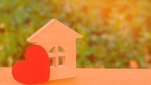 Picture of a small wooden house sitting next to a heart