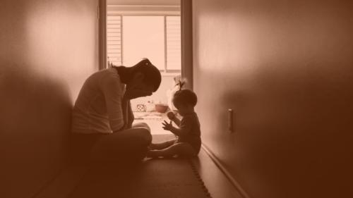 Stressed mom sitting in hallway with young child