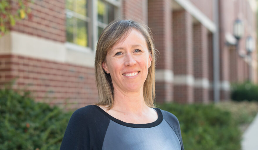 headshot of Christina Guarnieri, standing outside building